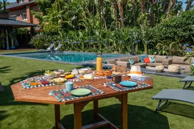 a picnic table with food on it next to a pool at BARCELONA´S TROPICAL OASIS in Sant Just Desvern
