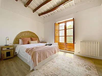 a bedroom with a large bed and a window at Historic House at Can Quintana by Casa de Elena in Pineda de Mar