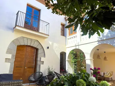 a building with a wooden door and a balcony at Historic House at Can Quintana by Casa de Elena in Pineda de Mar