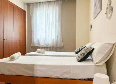 a bedroom with two beds and a window at Apt Mediterreanea Parking Terrazza Netflix Hostem in Vilanova i la Geltrú