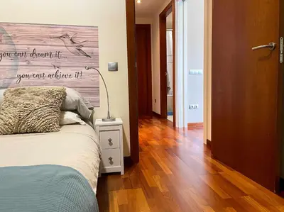 a bedroom with a bed with a wooden wall at Apt Mediterreanea Parking Terrazza Netflix Hostem in Vilanova i la Geltrú