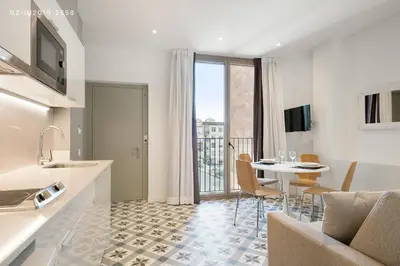 a kitchen and living room with a table and a dining room at Uma Suites Sagrada Familia in Barcelona