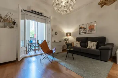 a living room with a couch and a chandelier at Eixample Apartment in Barcelona