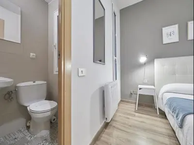a bathroom with a toilet and a bed and a sink at Gran Via Terrace Barcelona in Barcelona
