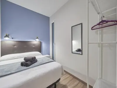 a teddy bear sitting on a bed in a bedroom at Gran Via Terrace Barcelona in Barcelona