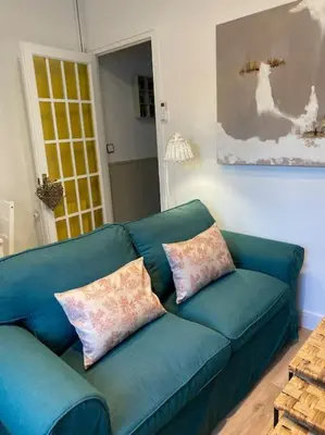 a blue couch with two pillows in a living room at Casita pueblo al lado Del Mar-Vilasardemarlux4 in Vilassar de Mar