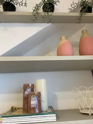 a shelf with two vases and a candle and books at Casita pueblo al lado Del Mar-Vilasardemarlux4 in Vilassar de Mar