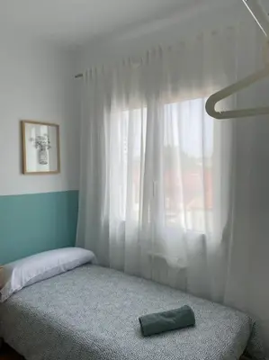 a bedroom with a bed and a window with a green pillow at Casita pueblo al lado Del Mar-Vilasardemarlux4 in Vilassar de Mar