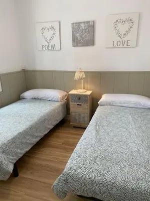 a bedroom with two beds and a table with a lamp at Casita pueblo al lado Del Mar-Vilasardemarlux4 in Vilassar de Mar