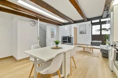 a dining room with a white table and chairs at Nice Central Loft in Vilanova i la Geltrú