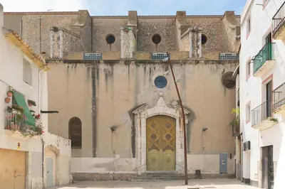 an old building with a door in a street at Nice Central Loft in Vilanova i la Geltrú