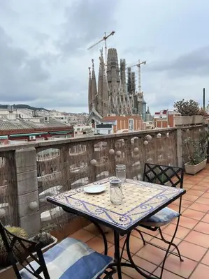 a table and chairs on a balcony with a view of a city at Sagrada Familia in Barcelona