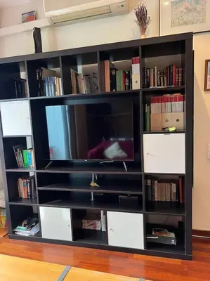a black book shelf with a flat screen tv at Sagrada Familia in Barcelona