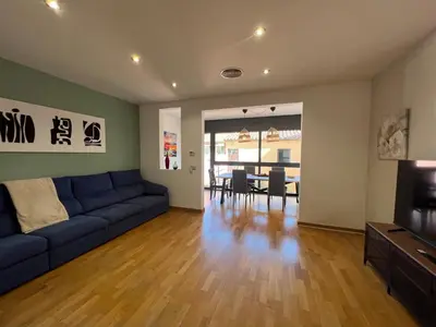 a living room with a blue couch and a dining room at CASA NEUS, Casa única cerca de Barcelona in Sant Feliu de Llobregat