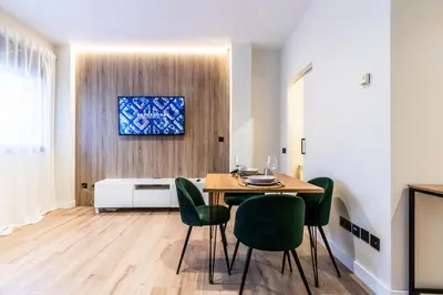 a dining room with a table and green chairs at Exclusive Apartments Barcelona 4 personas St Pere in Terrassa