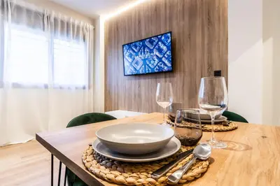 a dining room table with a bowl and two wine glasses at Exclusive Apartments Barcelona 4 personas St Pere in Terrassa