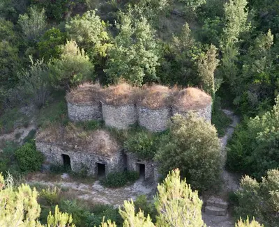 an old stone building on a hill with trees at APARTAMENTS PUIG GILI in Mura