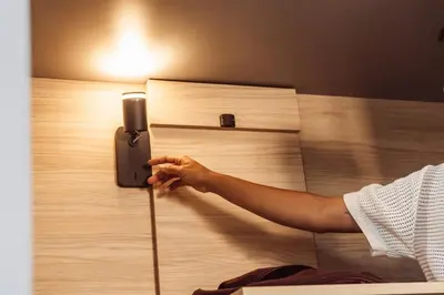 a person is putting a cell phone on a bed at Leevin Student Barcelona in Barcelona