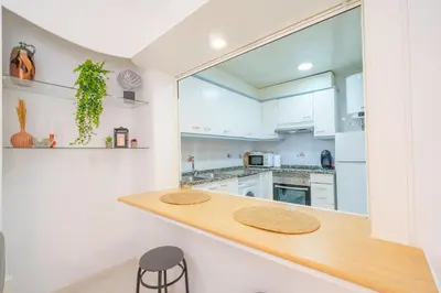 a kitchen with white cabinets and a wooden counter top at HomeHolidaysRentals Caliz - Costa Barcelona in Pineda de Mar