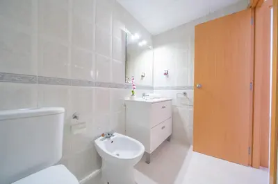 a white bathroom with a toilet and a sink at HomeHolidaysRentals Caliz - Costa Barcelona in Pineda de Mar