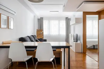 a living room with a dining table and white chairs at La Mejor Zona de Barcelona in Barcelona