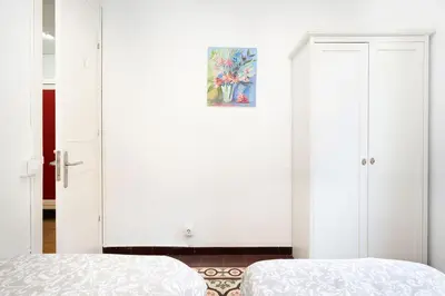 a bedroom with white walls and a door with a painting at Centric Apartments Sagrada Famila 3 in Barcelona