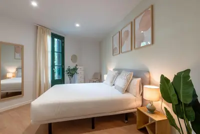 a white bedroom with a bed and a mirror at CATERINA Sant Pau in Barcelona
