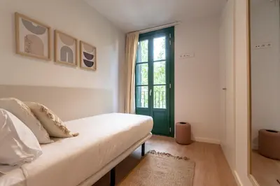 a bedroom with a white bed and a green door at CATERINA Sant Pau in Barcelona