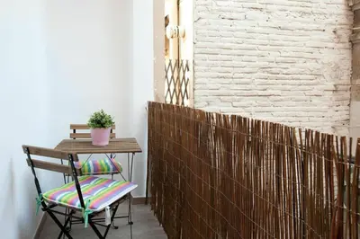 a chair sitting next to a table and a brick wall at Bed&BCN Enamorats in Barcelona