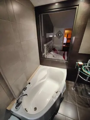 a bathroom with a white tub and a mirror at Hostal Manel in Pineda de Mar