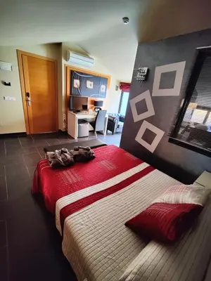 a bedroom with a large bed with a red blanket at Hostal Manel in Pineda de Mar