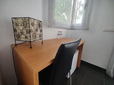 a wooden desk with a chair next to a window at Hostal Manel in Pineda de Mar