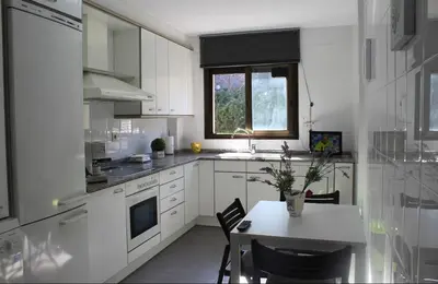 a white kitchen with a table and a window at Barcelo al riu in Monistrol