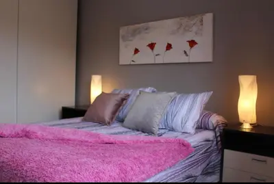 a bedroom with a pink bed with a pink blanket at Barcelo al riu in Monistrol