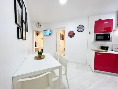 a kitchen and dining room with a white table and chairs at Suite Miro Eixample Barcelona in Barcelona