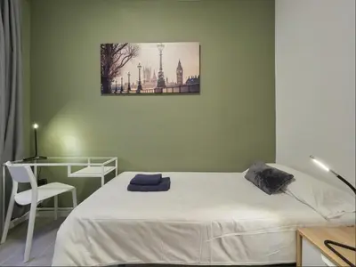 a bedroom with a bed and a desk and a picture on the wall at Sagrada Familia Penthouse in Barcelona
