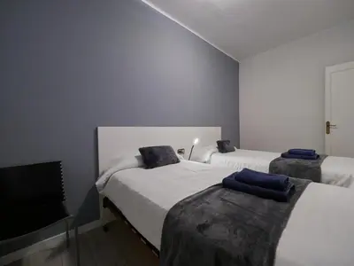 a bedroom with two beds and a flat screen tv at Sagrada Familia Penthouse in Barcelona