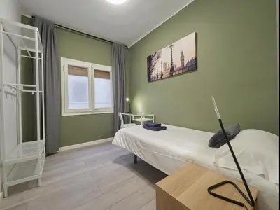 a green room with a bed and a window at Sagrada Familia Penthouse in Barcelona