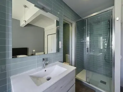 a bathroom with a sink and a glass shower at Sagrada Familia Penthouse in Barcelona