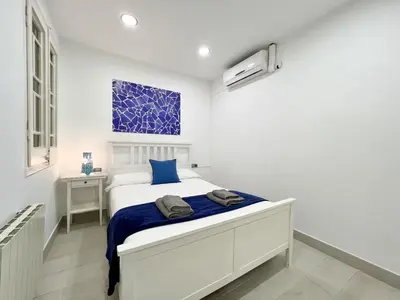 a bedroom with a white bed with blue sheets at Sagrada Familia Gaudi in Barcelona