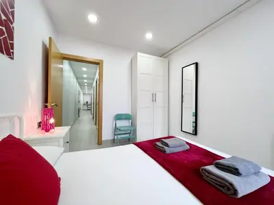 a bedroom with a large white bed with a red blanket at Sagrada Familia Gaudi in Barcelona