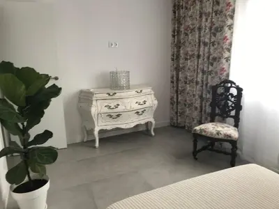 a bedroom with a dresser and a chair and a plant at Campagne luxueuse de Sitges in Olivella