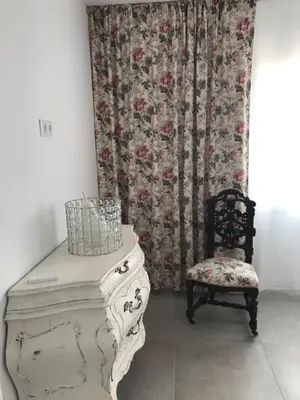 a chair and a dresser in a room with a curtain at Campagne luxueuse de Sitges in Olivella
