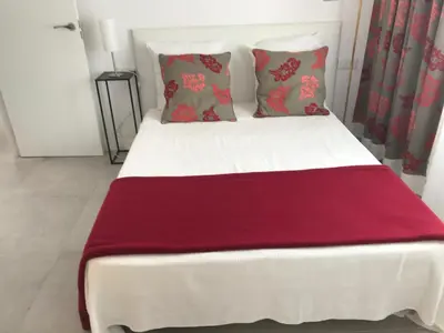 a white bed with a red blanket on it at Campagne luxueuse de Sitges in Olivella