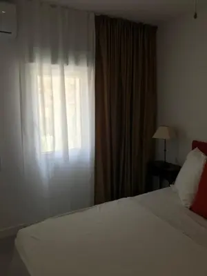 a bedroom with a white bed and a window at Campagne luxueuse de Sitges in Olivella