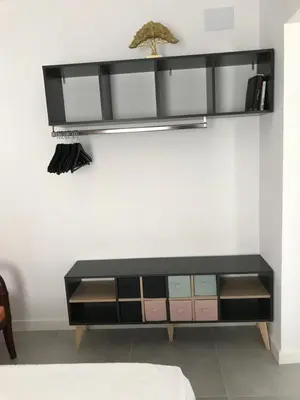 a black dresser with a shelf on a wall at Campagne luxueuse de Sitges in Olivella