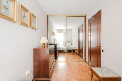 a hallway with a table and a room with a bed at AB Paralel Blai Apartment in Barcelona