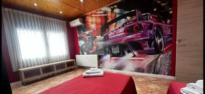 a room with a red table with a car on the wall at Villa Oasis entre Viñedos cerca de Barcelona con A A y piscina climatizada in Caserío de Caʼn Rosell