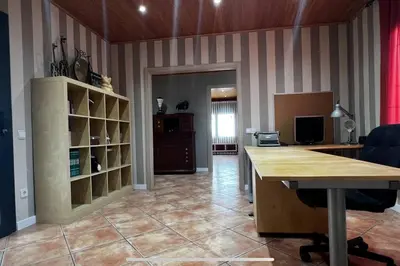 a living room with a table and a book shelf at Villa Oasis entre Viñedos cerca de Barcelona con A A y piscina climatizada in Caserío de Caʼn Rosell