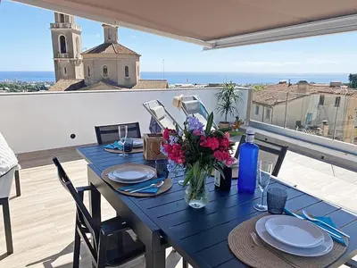a blue table with flowers on top of a balcony at Ses Voltes Boutique Home Sea and Sky in Vilassar de Dalt